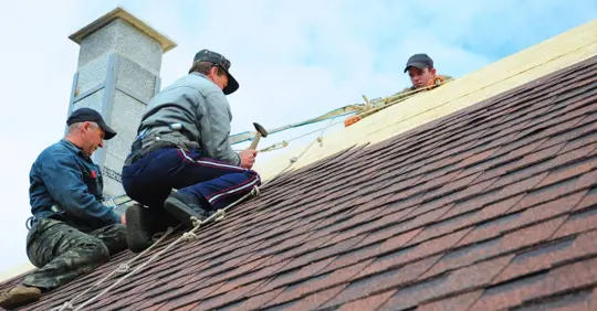 Roofing crew installing shingle roof