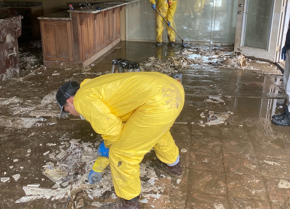 Monarch Restoration specialists cleaning living space from flood damage.